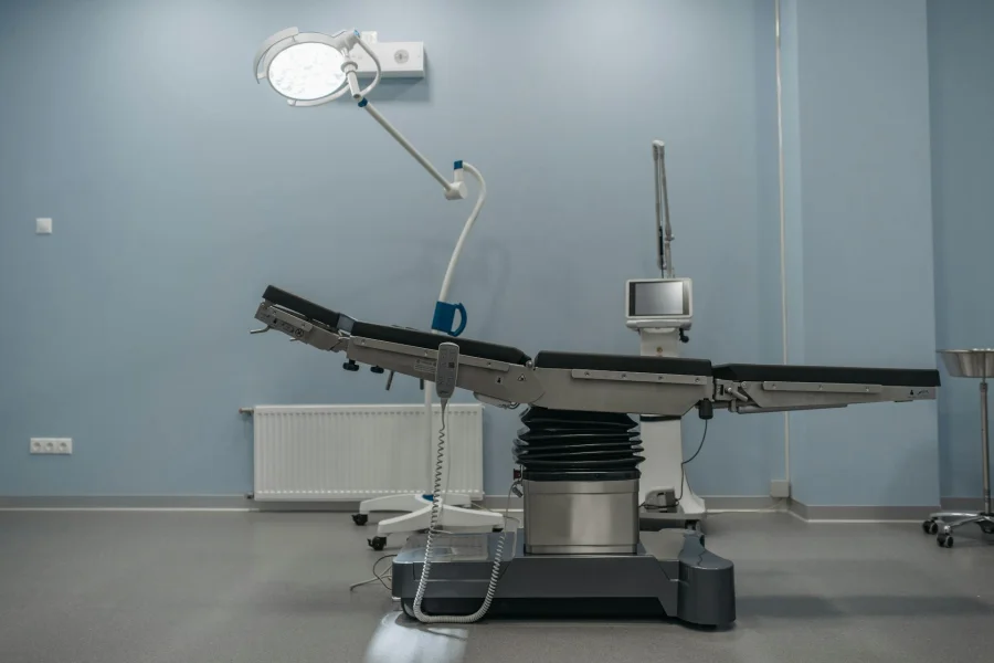 A clean, modern operating theatre with a surgical table and light