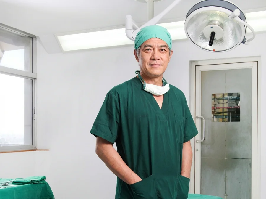 A Thai surgeon in scrubs standing in an operating theatre