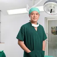 A Thai surgeon in scrubs standing in an operating theatre