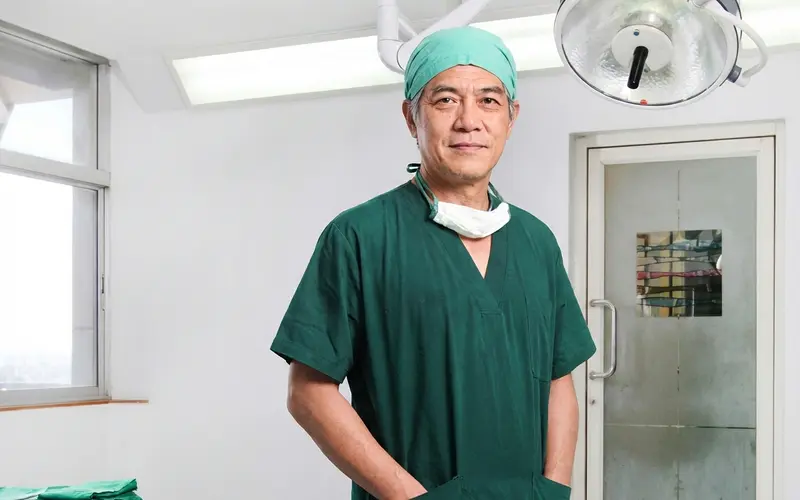 A Thai surgeon in scrubs standing in an operating theatre